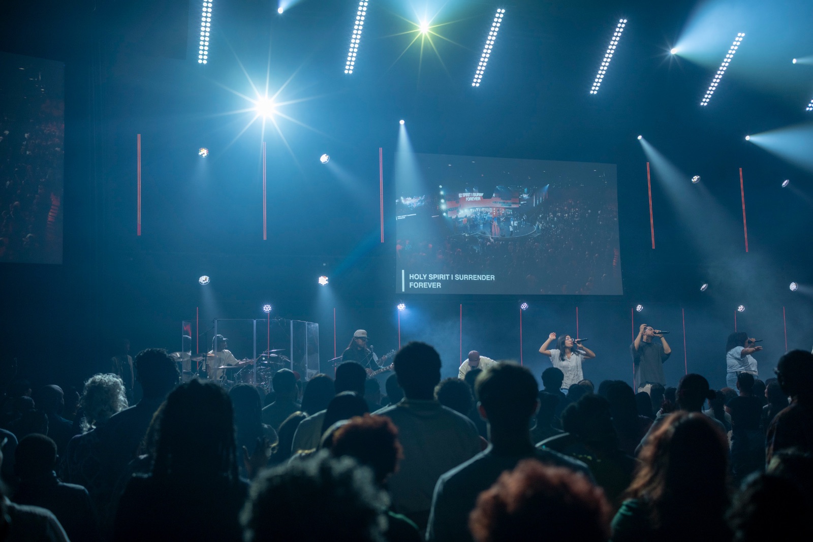 Jaywill playing drums on a large worship stage in front of a full crowd